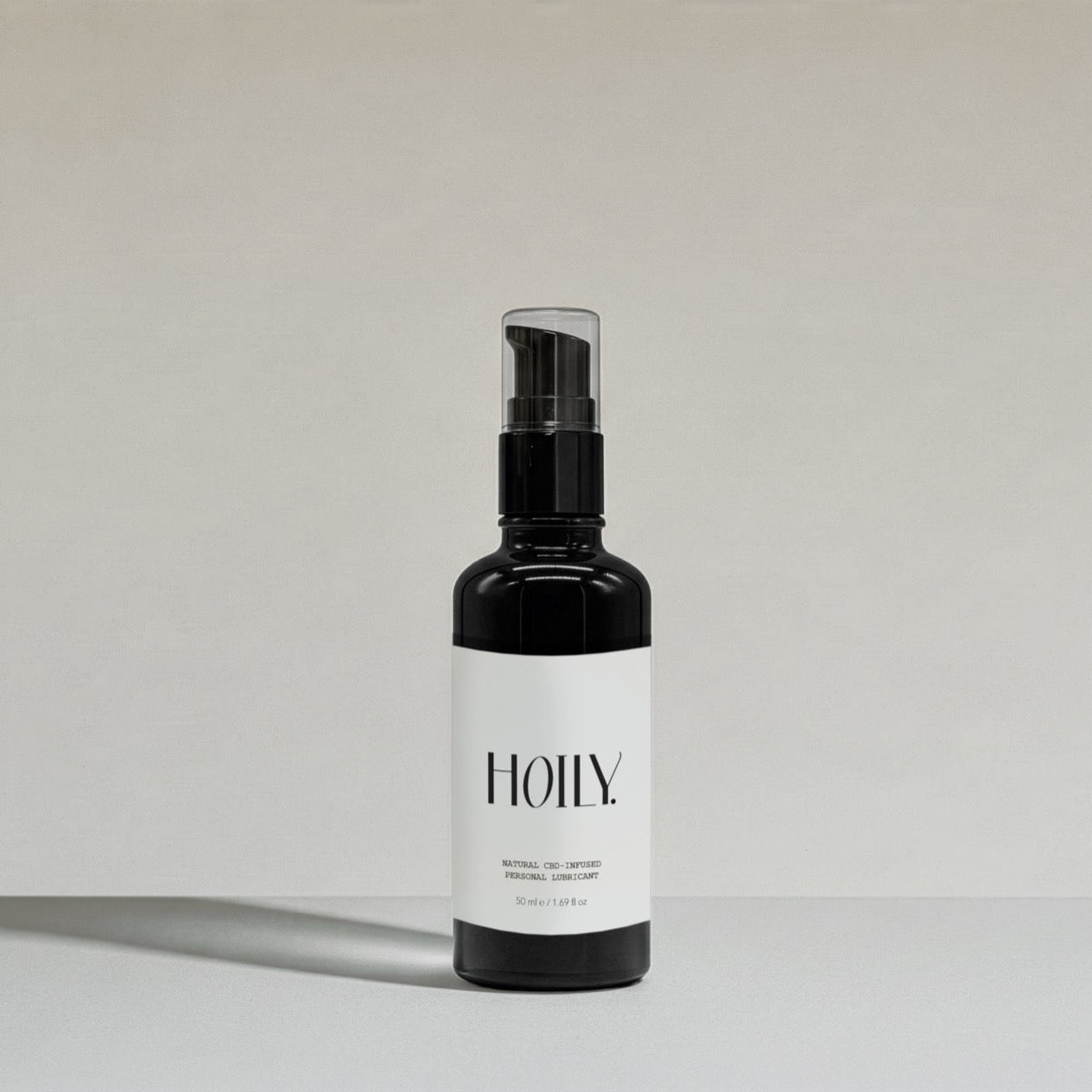 Black HOILY Natural CBD personal lubricant spray bottle on a light grey background